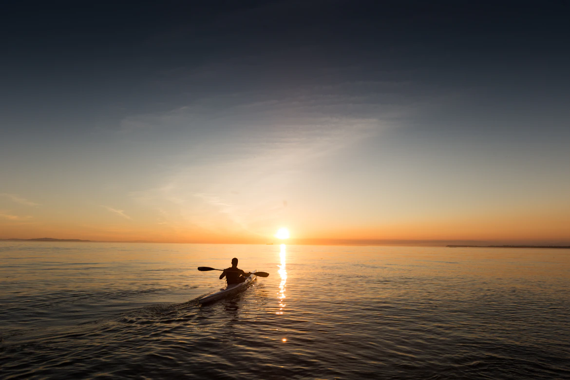 Kayakiste en mer au coucher du soleil
